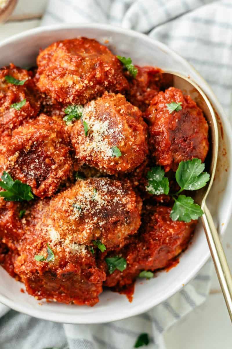 Yummy keto meatballs in a bowl with grated Parmesan on top, ready to satisfy your taste buds.