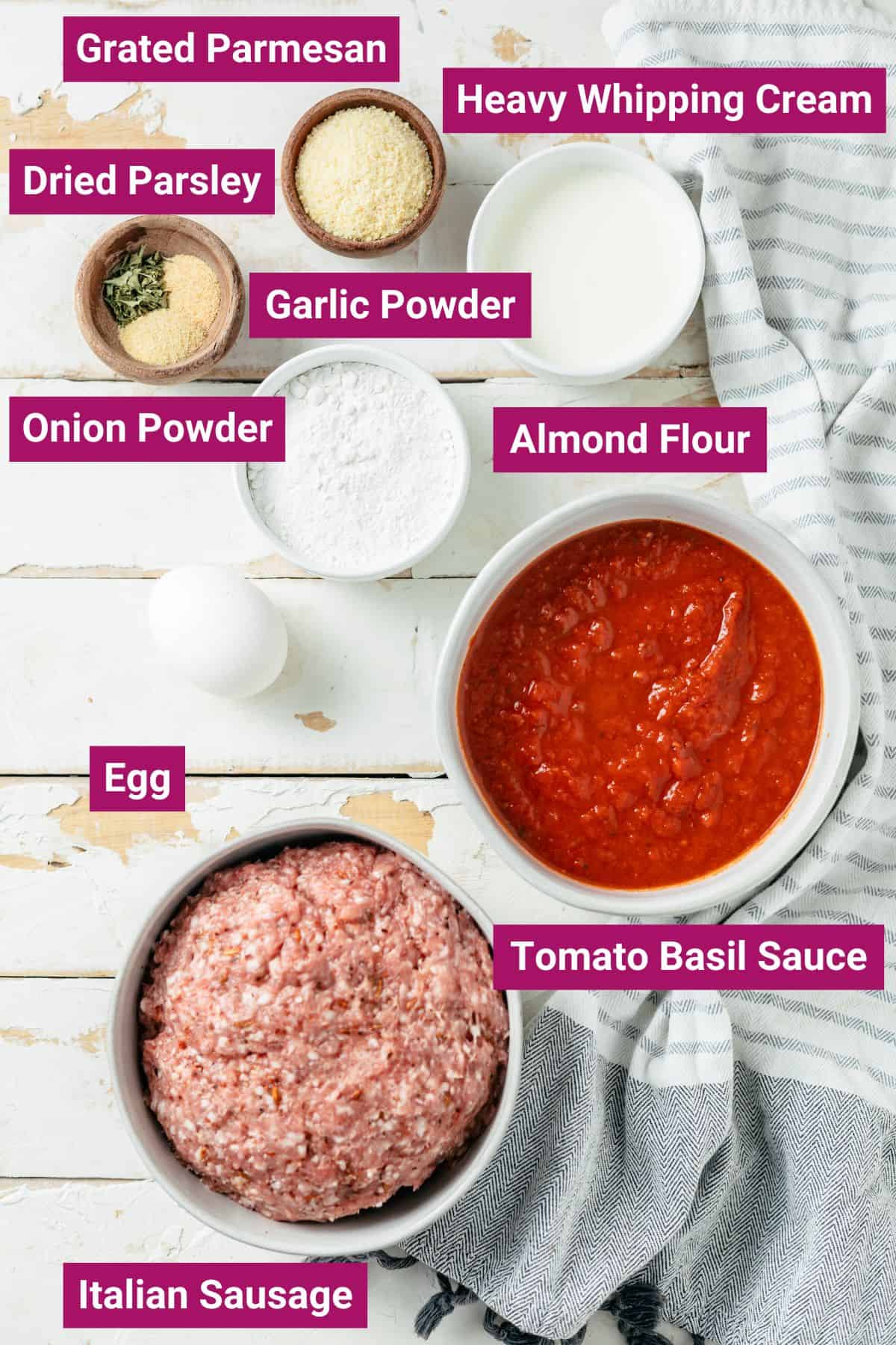 Ingredients for mouthwatering meatballs individually presented in bowls include Italian sausage (casing removed), almond flour, beaten eggs, heavy whipping cream, onion powder, garlic powder, dried parsley, grated Parmesan, and tomato basil sauce