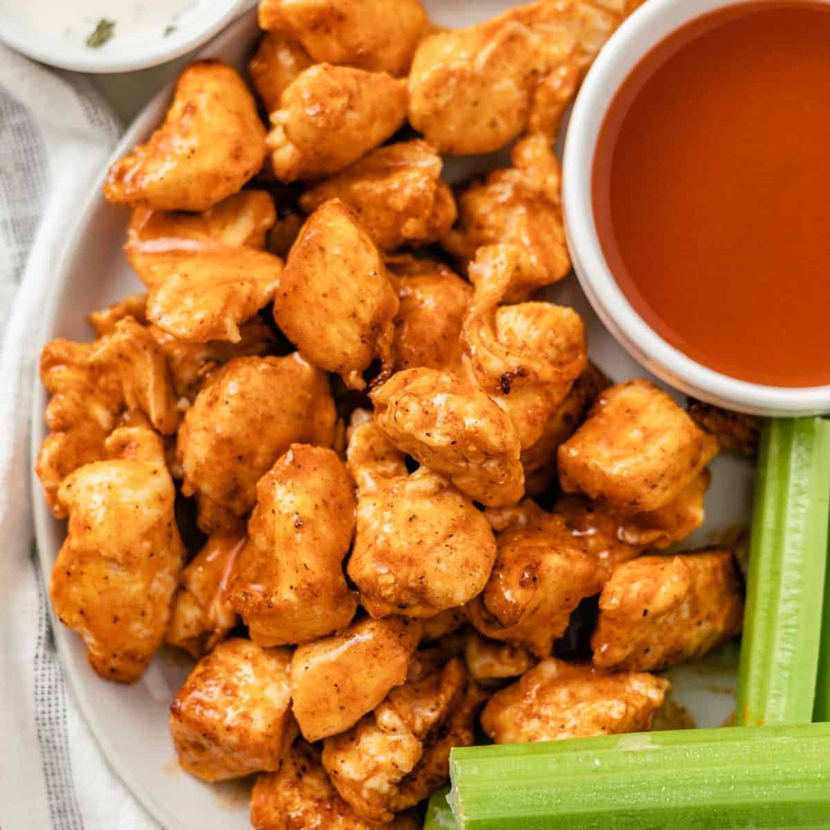 plated air fryer buffalo chicken bites with homemade blue cheese dressing, hot sauce and celery sticks