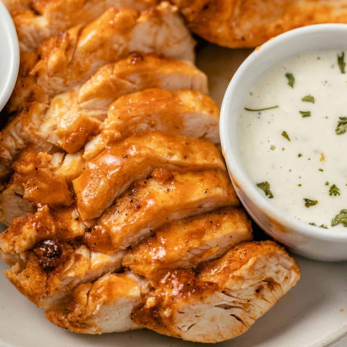 air fryer buffalo chicken breasts plated with blue cheese dressing