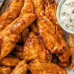 plated air fryer buffalo chicken tenders with a cup of blue cheese dressing