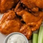 air fryer buffalo chicken thighs with dipping sauce and fresh celery sticks for crunch