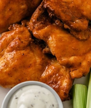 air fryer buffalo chicken thighs with dipping sauce and fresh celery sticks for crunch