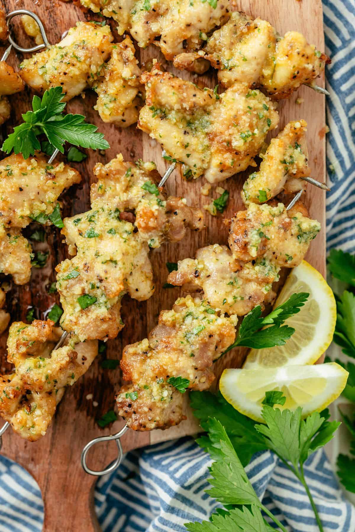 air fryer chicken skewers with 2 lemon slices served on a wooden board