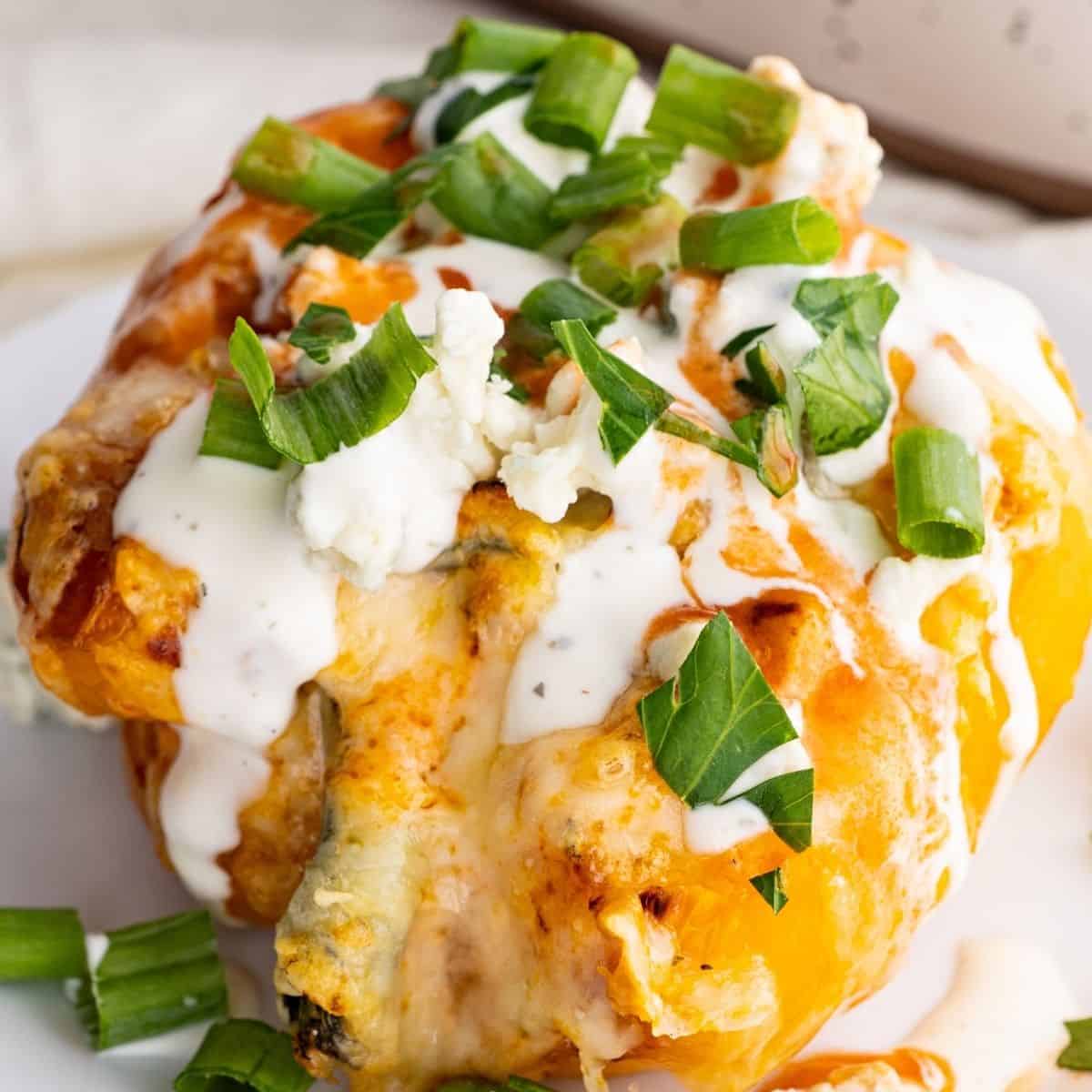 buffalo chicken stuffed pepper topped with ranch dressing, blue cheese, and extra hot sauce