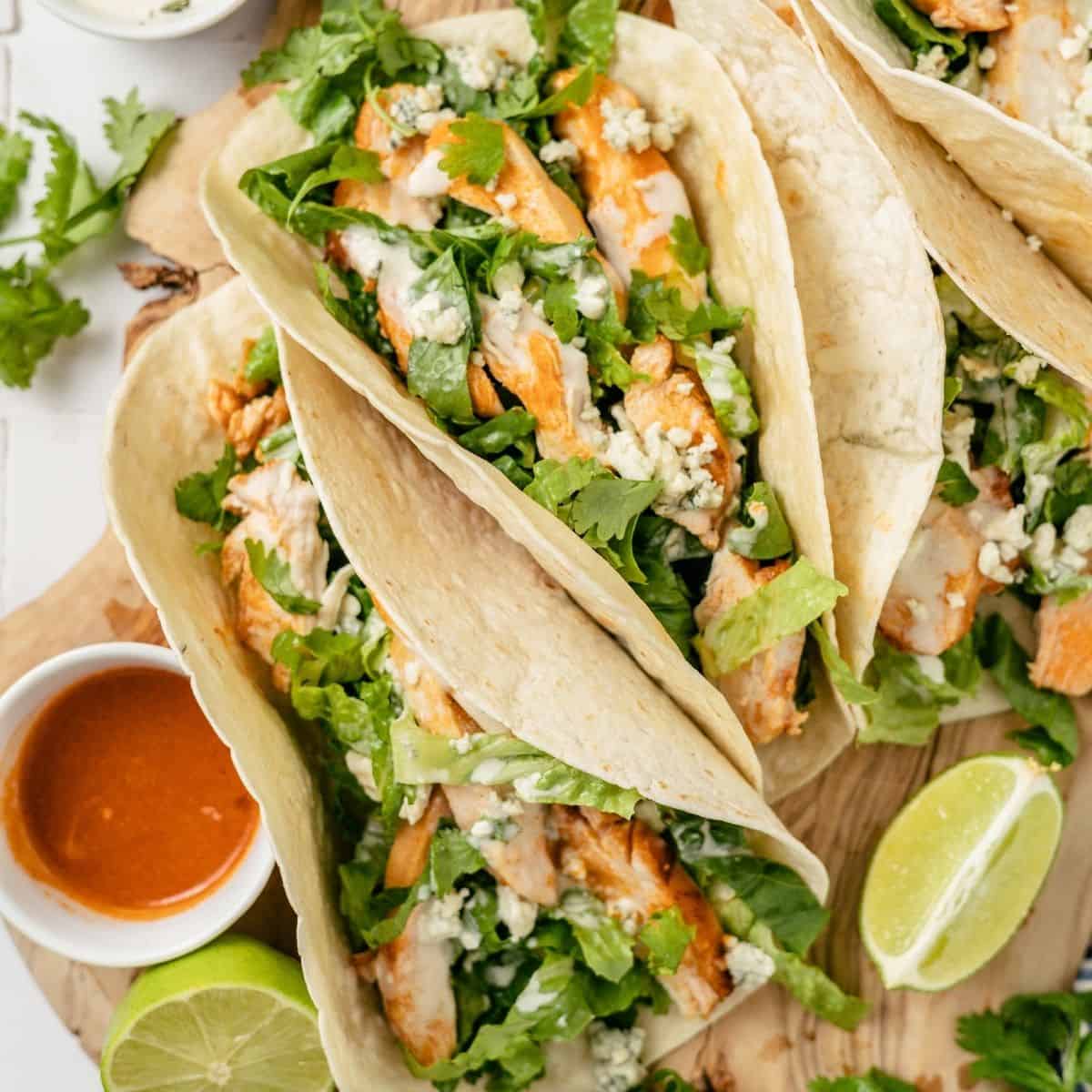 buffalo chicken tacos with a side of spicy hot sauce