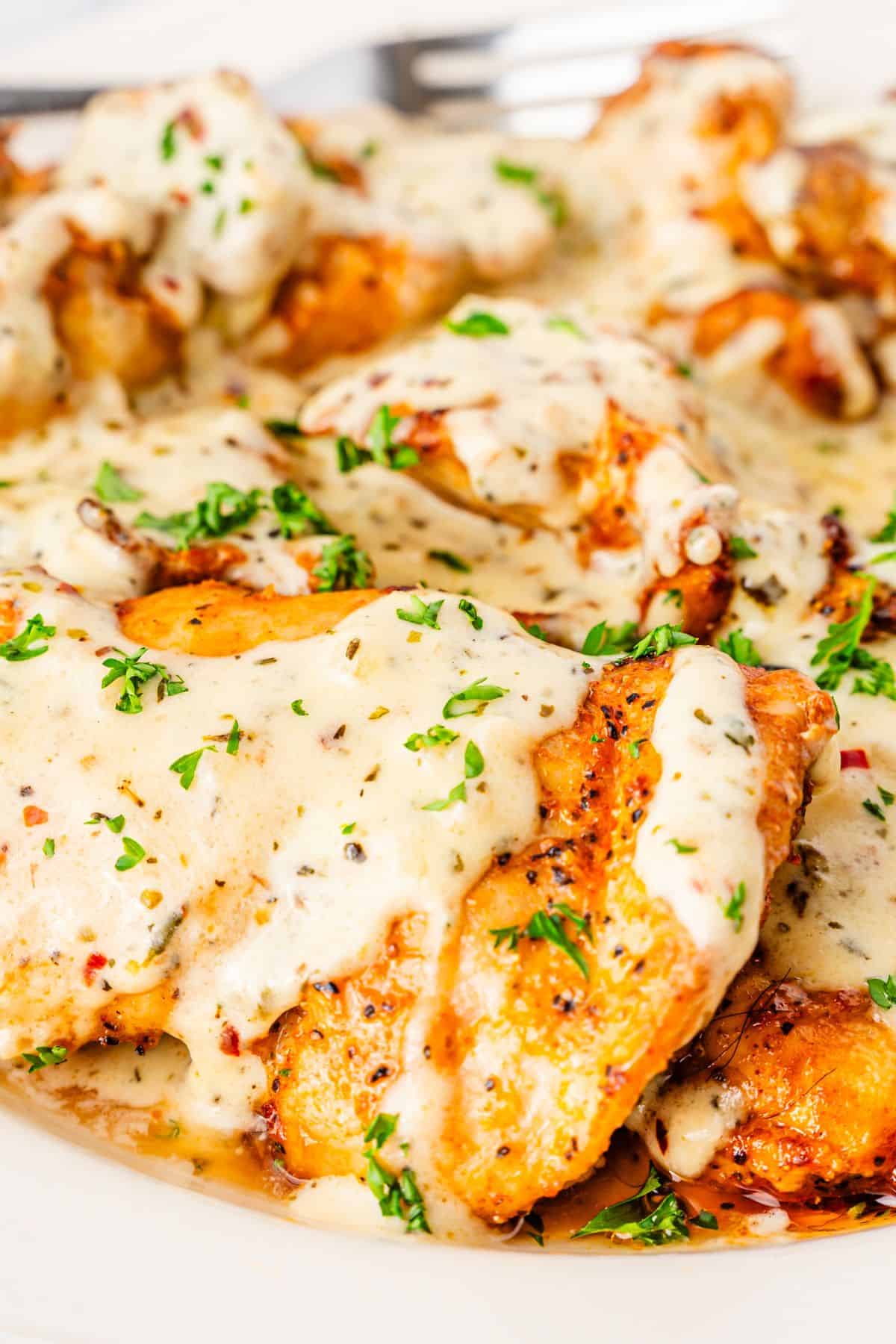 flavorful garlic parmesan chicken thighs with creamy sauce and fresh parsley garnish