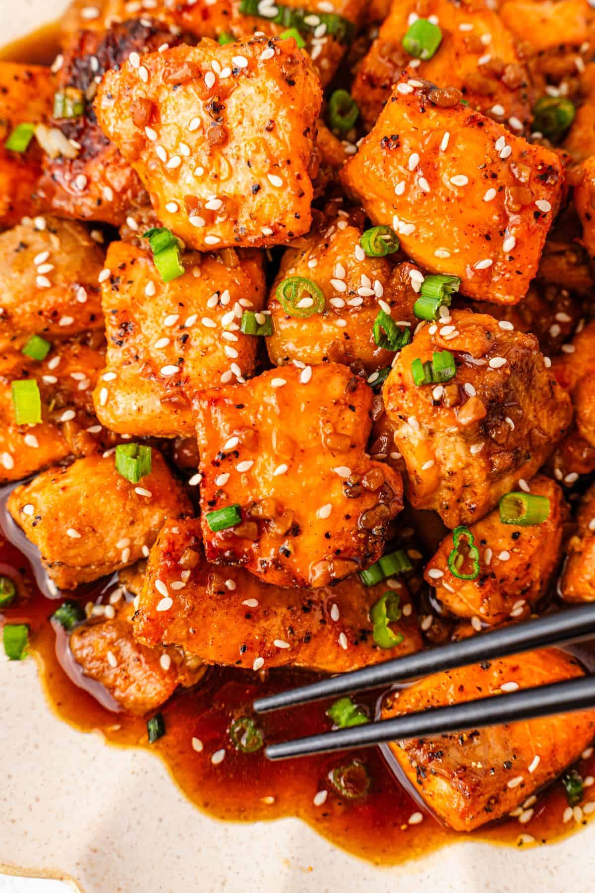 honey garlic salmon bites with rich honey garlic sauce topped with chopped green onions