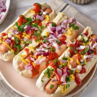hot dog sandwiches with red onion and sauce, ready to eat