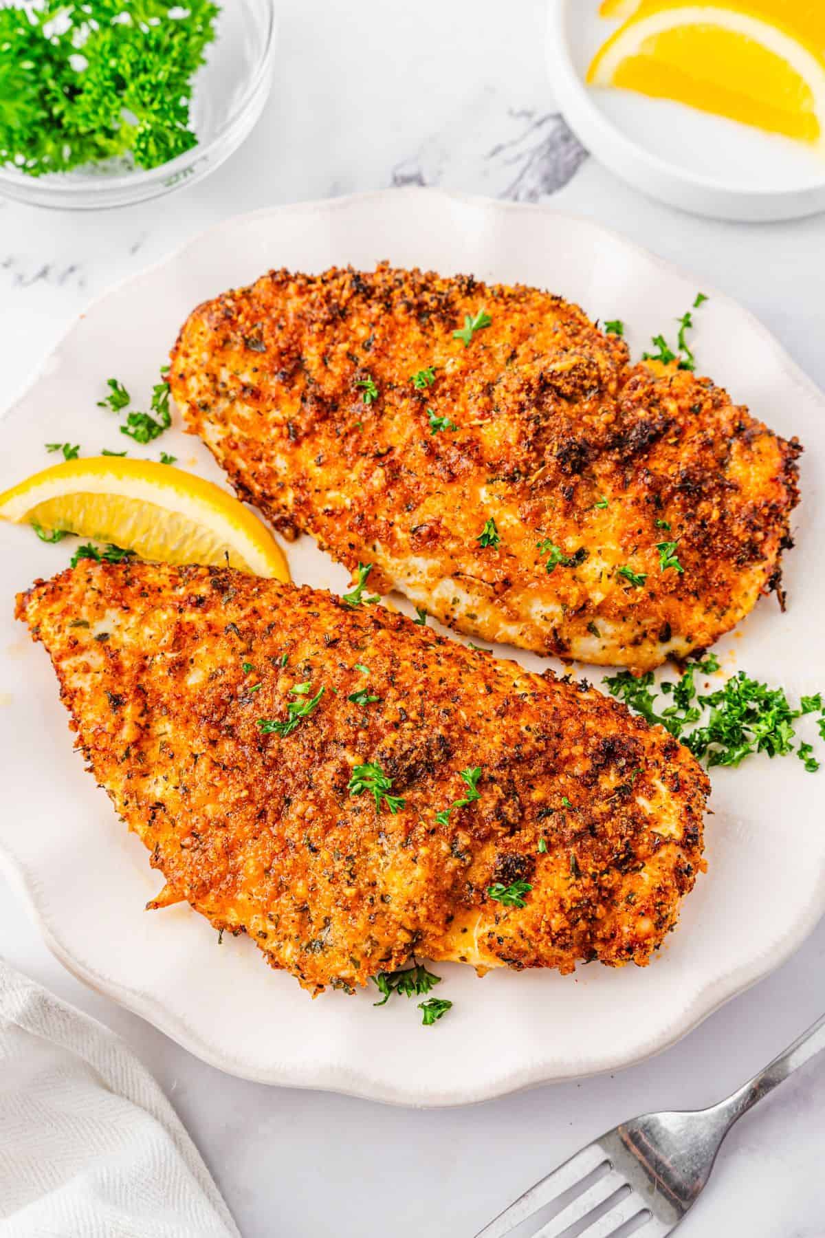 Air fried Parmesan chicken breast with crunchy coating on white plate