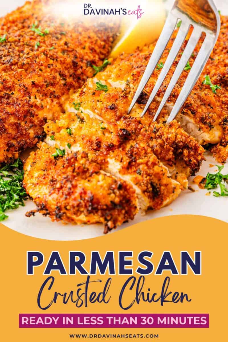 Parmesan crusted chicken breast on a white plate with golden crispy coating