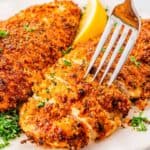Homemade Parmesan crusted chicken breast ready to serve on white plate