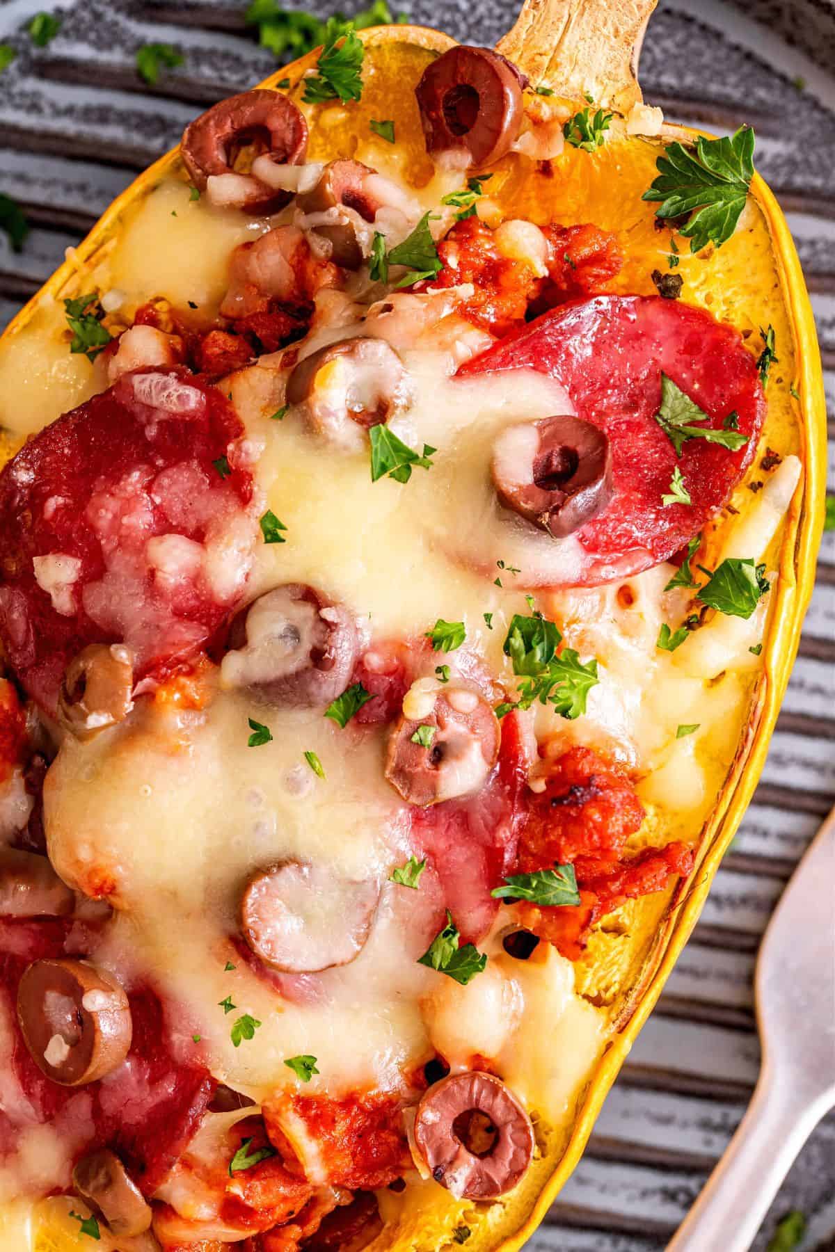 Cheesy pizza spaghetti squash served in a roasted squash shell with Italian sausage