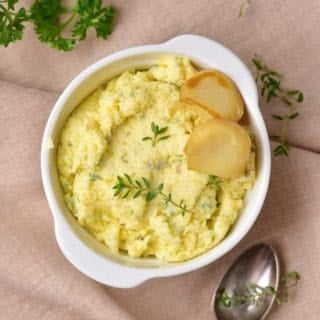 Homemade roasted garlic butter garnished with parsley in a bowl