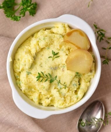 Homemade roasted garlic butter garnished with parsley in a bowl