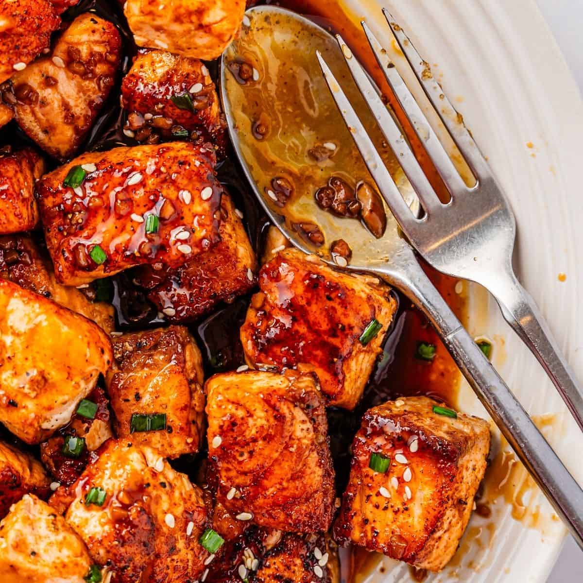 Crisp-edged salmon bites tossed in teriyaki sauce and topped with chives