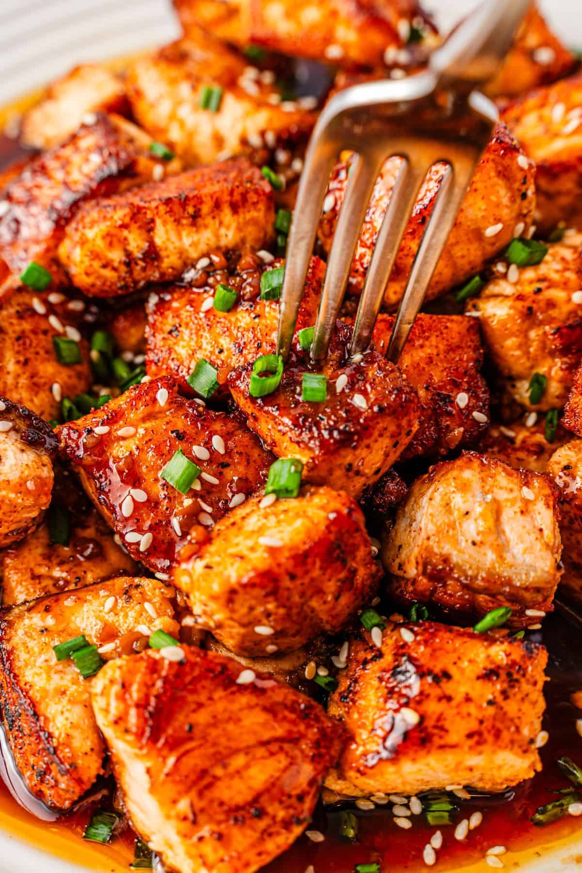 Pan-seared teriyaki salmon bites garnished with bright green chives