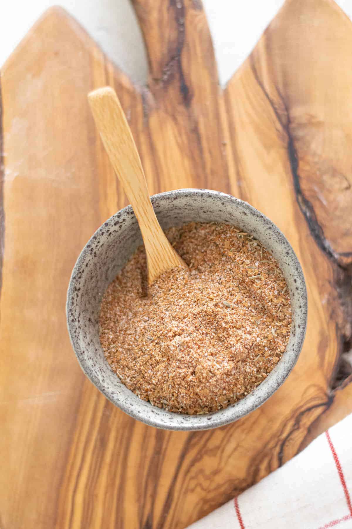 Jamaican jerk seasoning in a bowl with a spoon, ready to mix into pork, shrimp, or roasted vegetables