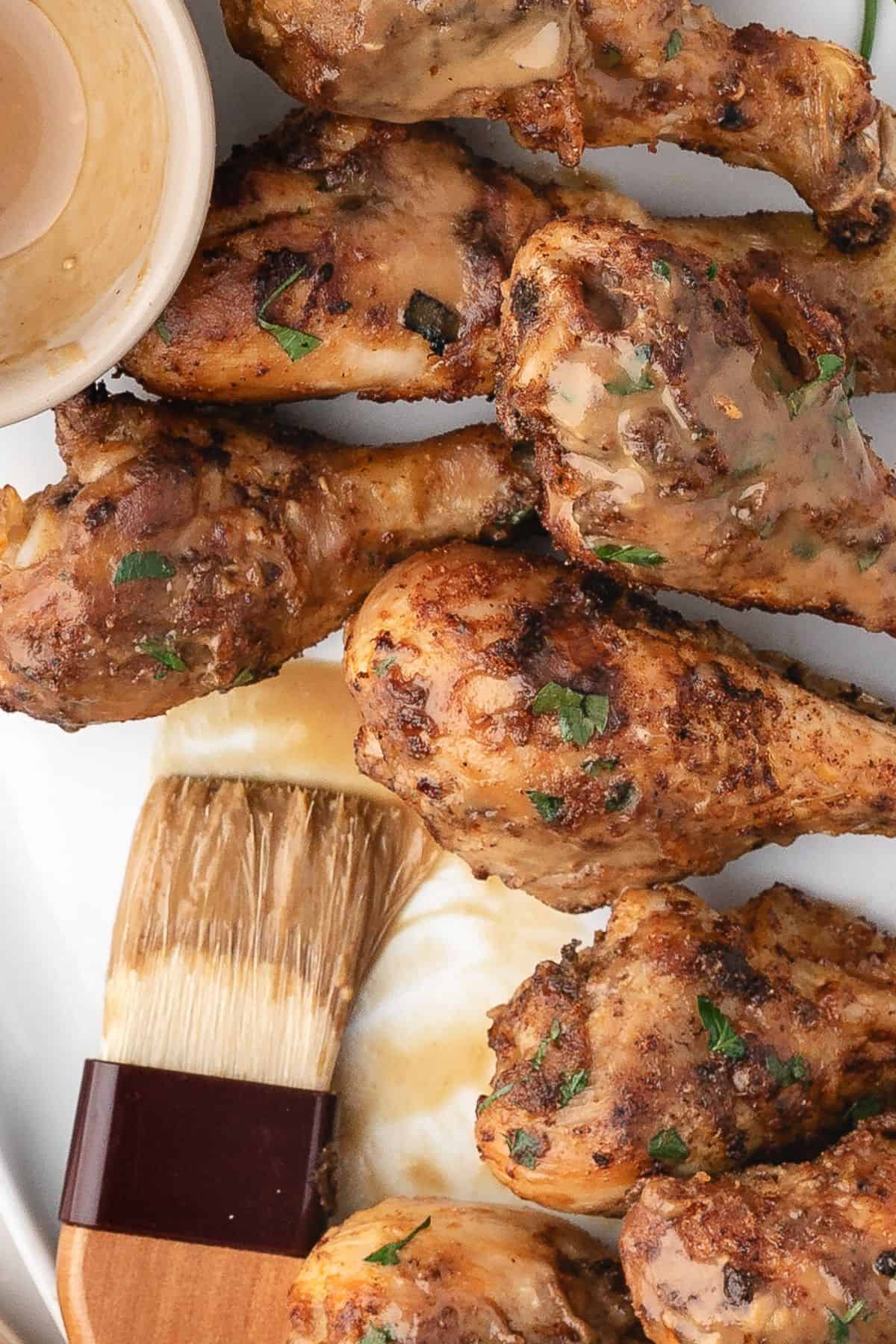 Baked chicken drumsticks caramelized with maple Dijon, garnished with herbs