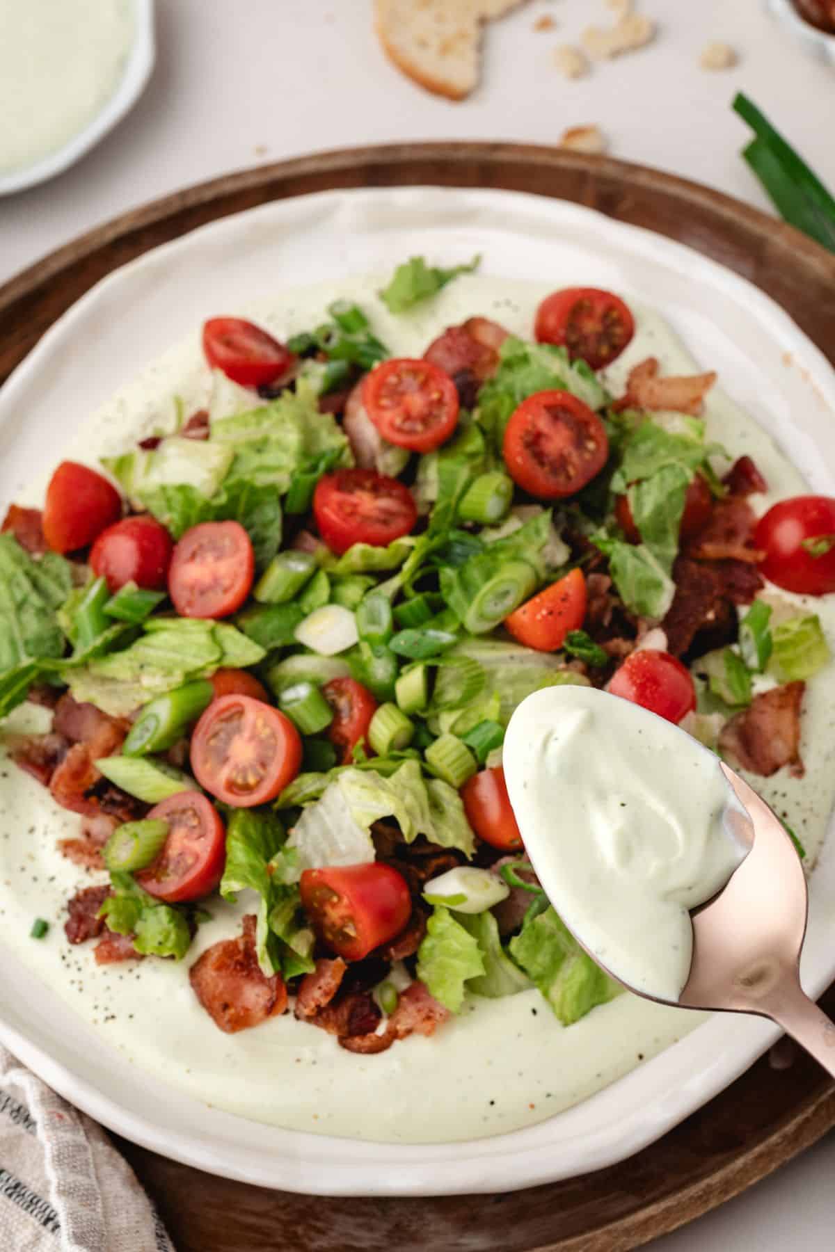 Scoopable BLT dip on a plate, featuring creamy avocado ranch and fresh BLT toppings