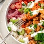Homemade buffalo chicken bowl layered with rice, veggies, and melted cheese
