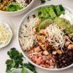 Chopped chipotle chicken in a large bowl with avocado and red onion