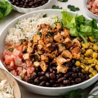 Smoky chipotle chicken pieces layered over a bed of rice and vegetables