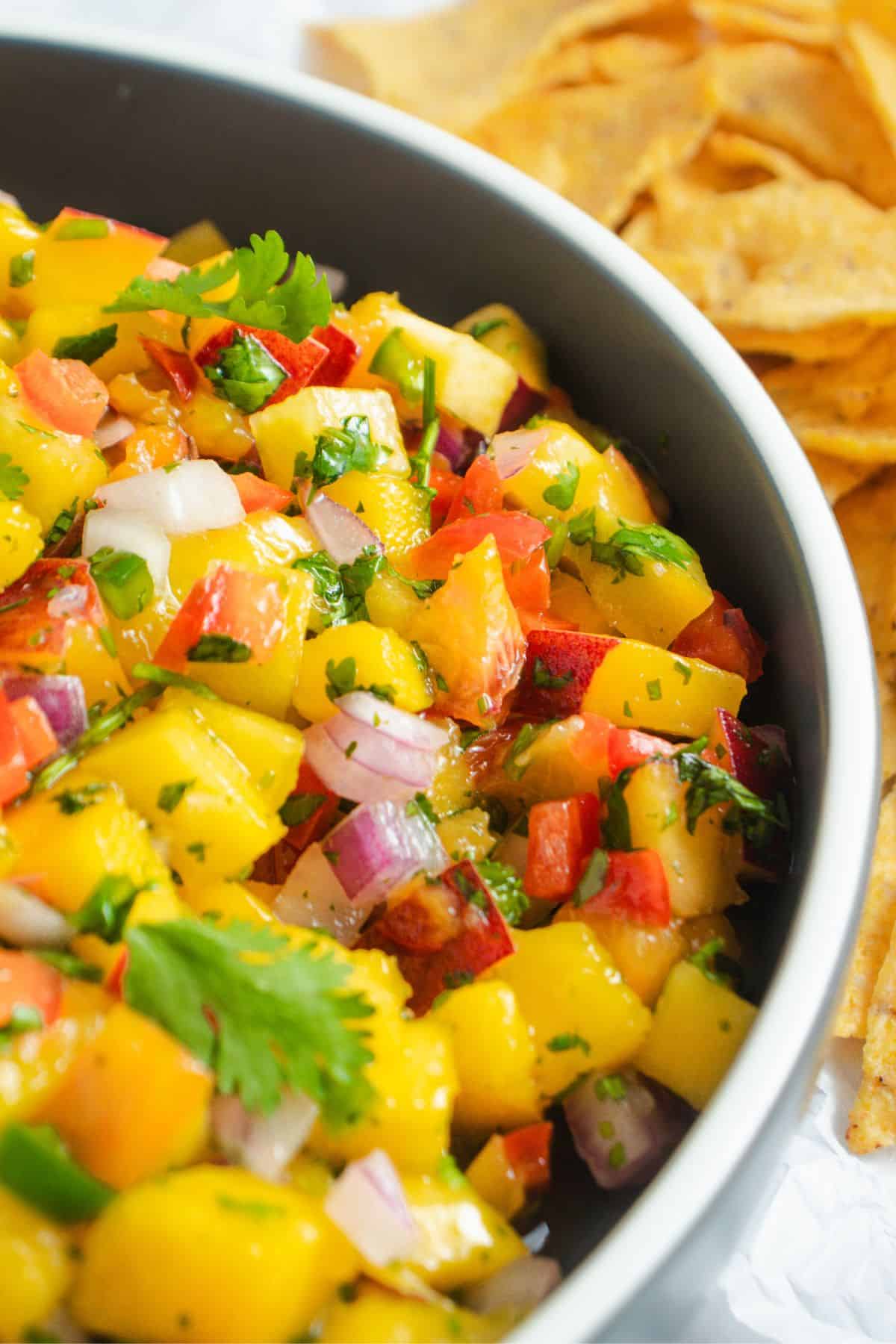 Fresh mango peach salsa used as a topping for grilled chicken or fish