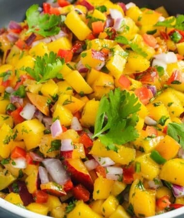 Fresh mango and peach salsa with lime, jalapeño, red onion, and cilantro