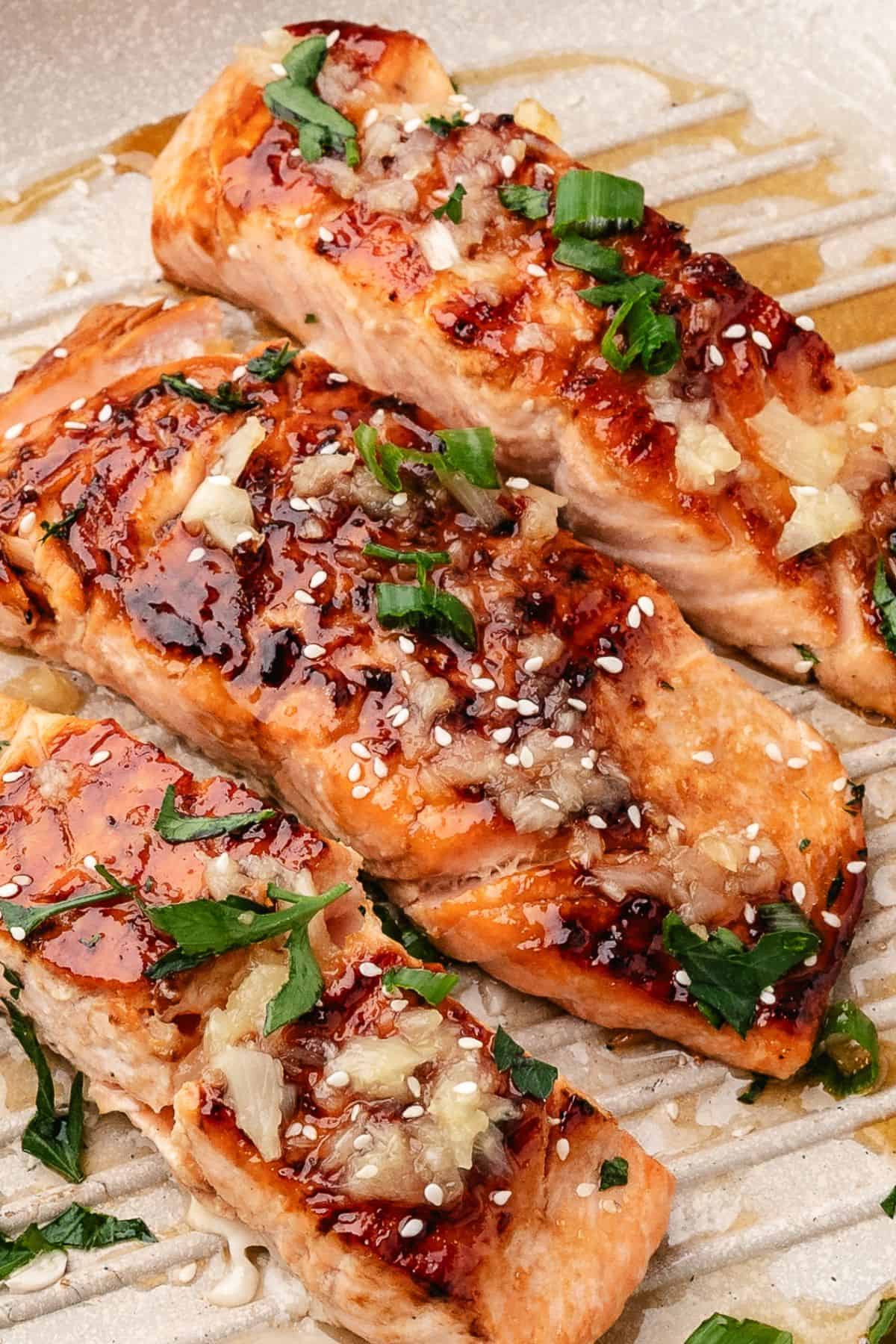 miso glazed salmon in a cast iron skillet topped with a sesame pineapple lime sauce.