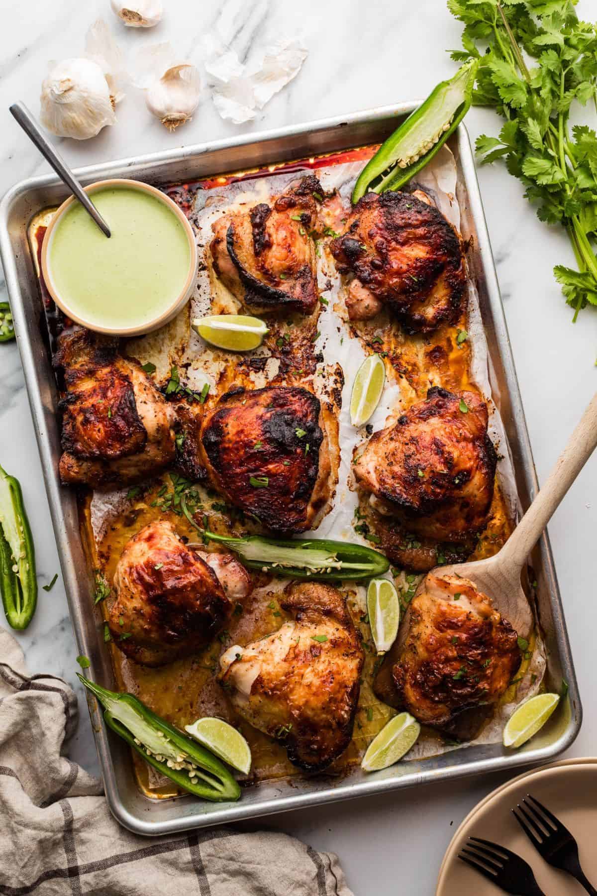 Peruvian roasted chicken with crispy skin and flavorful green sauce on the side