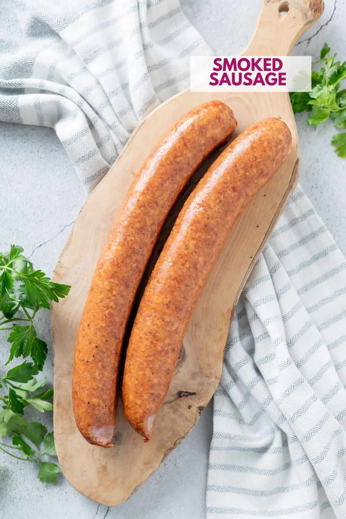 2 pieces of smoked sausage on a cutting board before being cooked