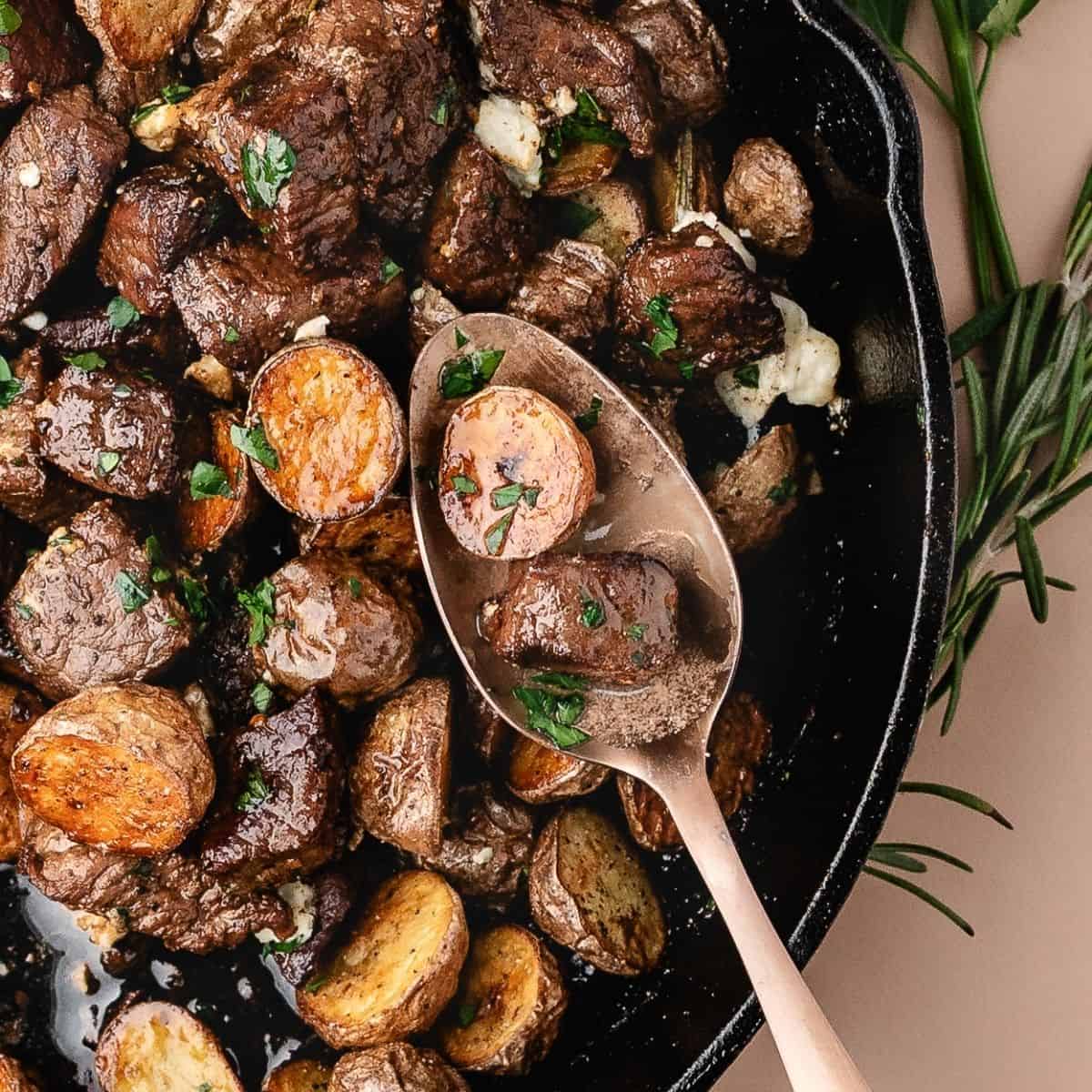 Sizzling steak bites with roasted potato cubes finished with melted blue cheese
