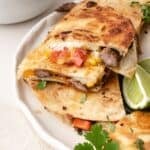 Plated steak quesadilla triangles with tender steak, sautéed vegetables, and melted cheese