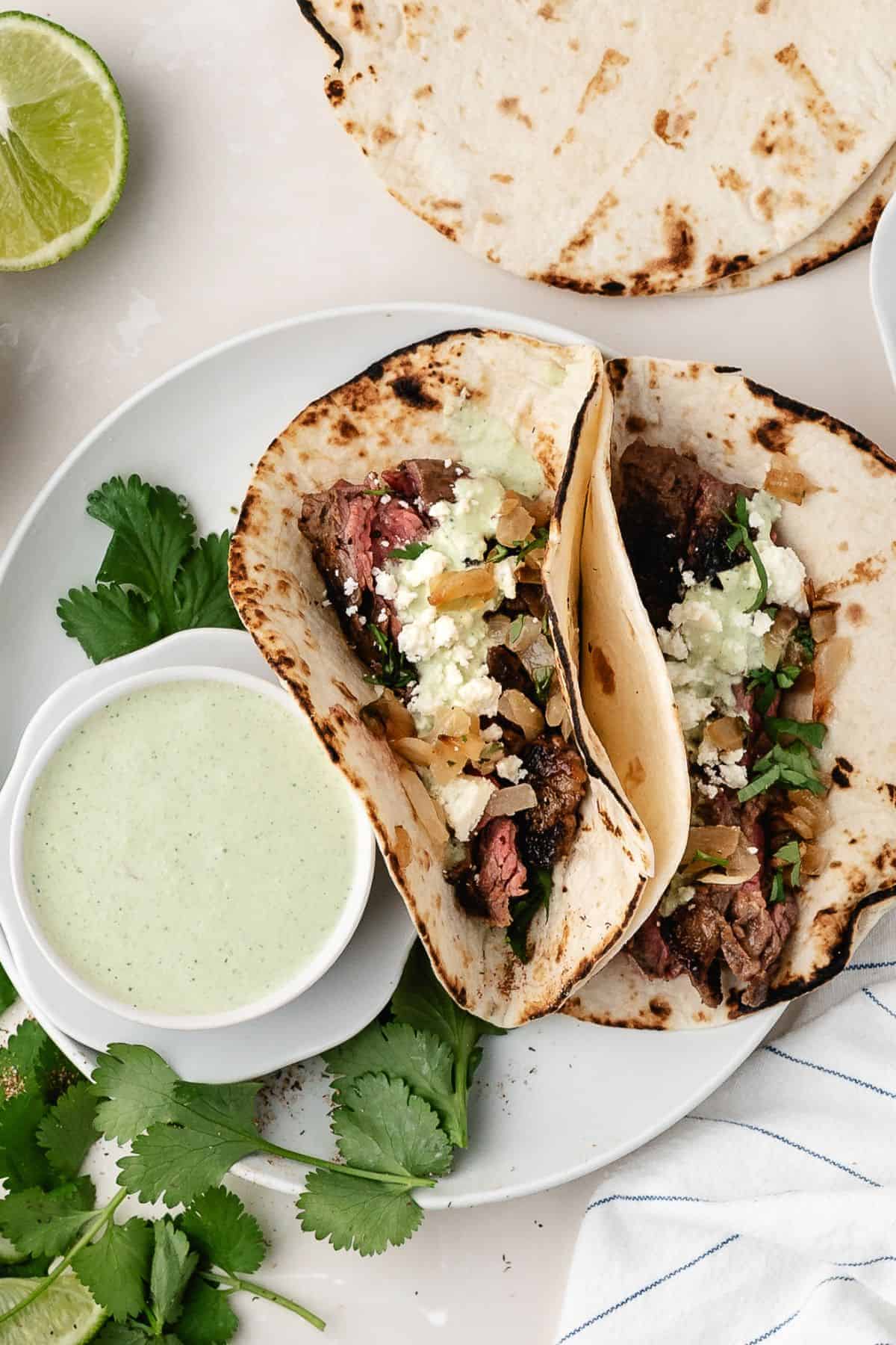 Tender steak tacos with a zesty citrus marinade, creamy avocado topping, and cotija cheese