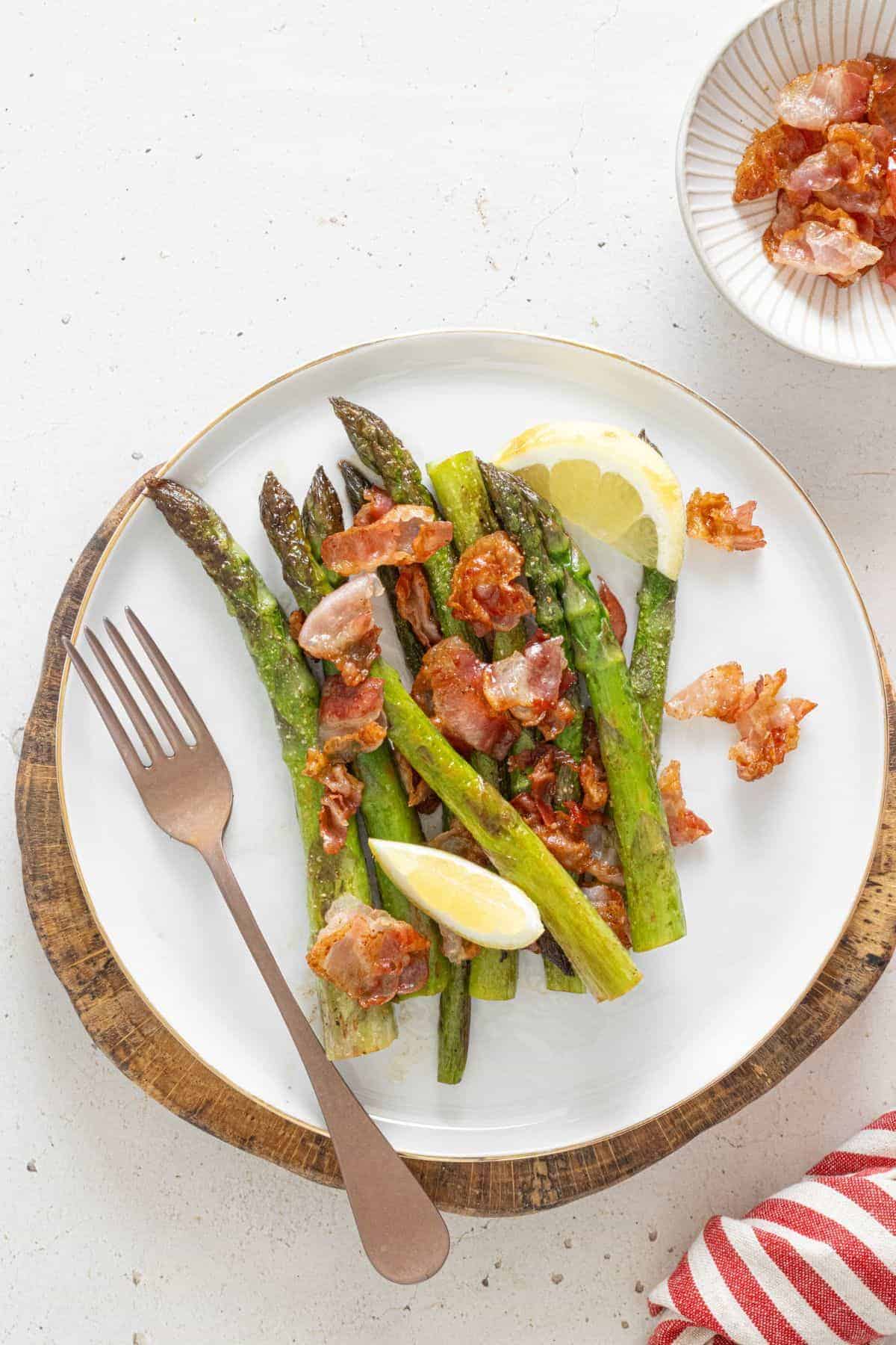 Plate of asparagus tossed with crispy bacon and lemon flavor