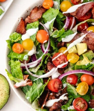 bacon, lettuce and tomato salad with avocado and ranch dressing in a bowl