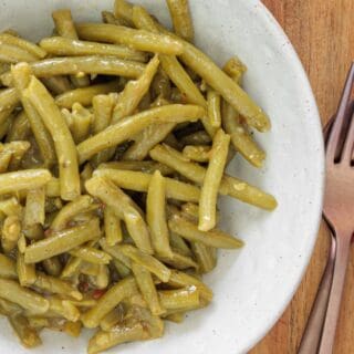 Canned green beans cooked with garlic, butter, and salt on a plate