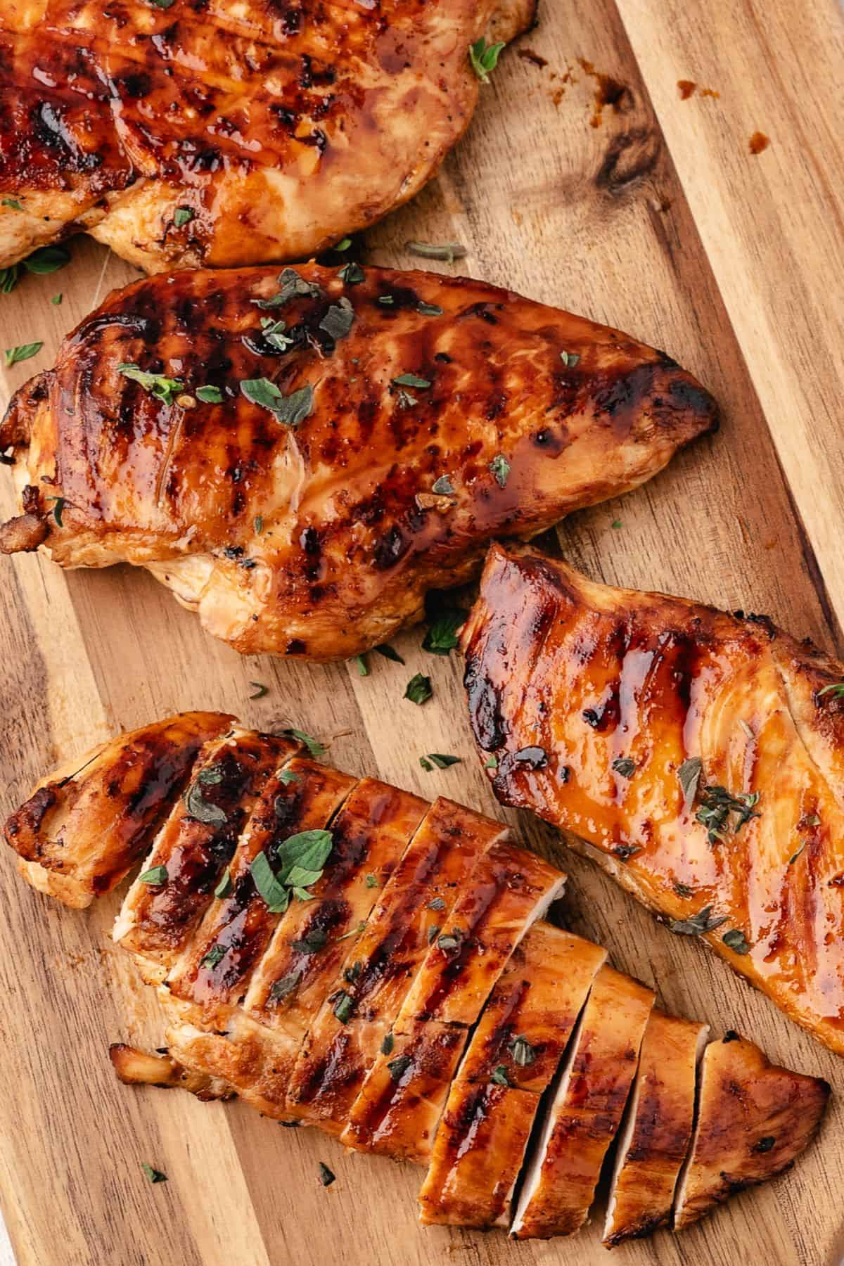Fresh marinated chicken breasts arranged on a wooden board