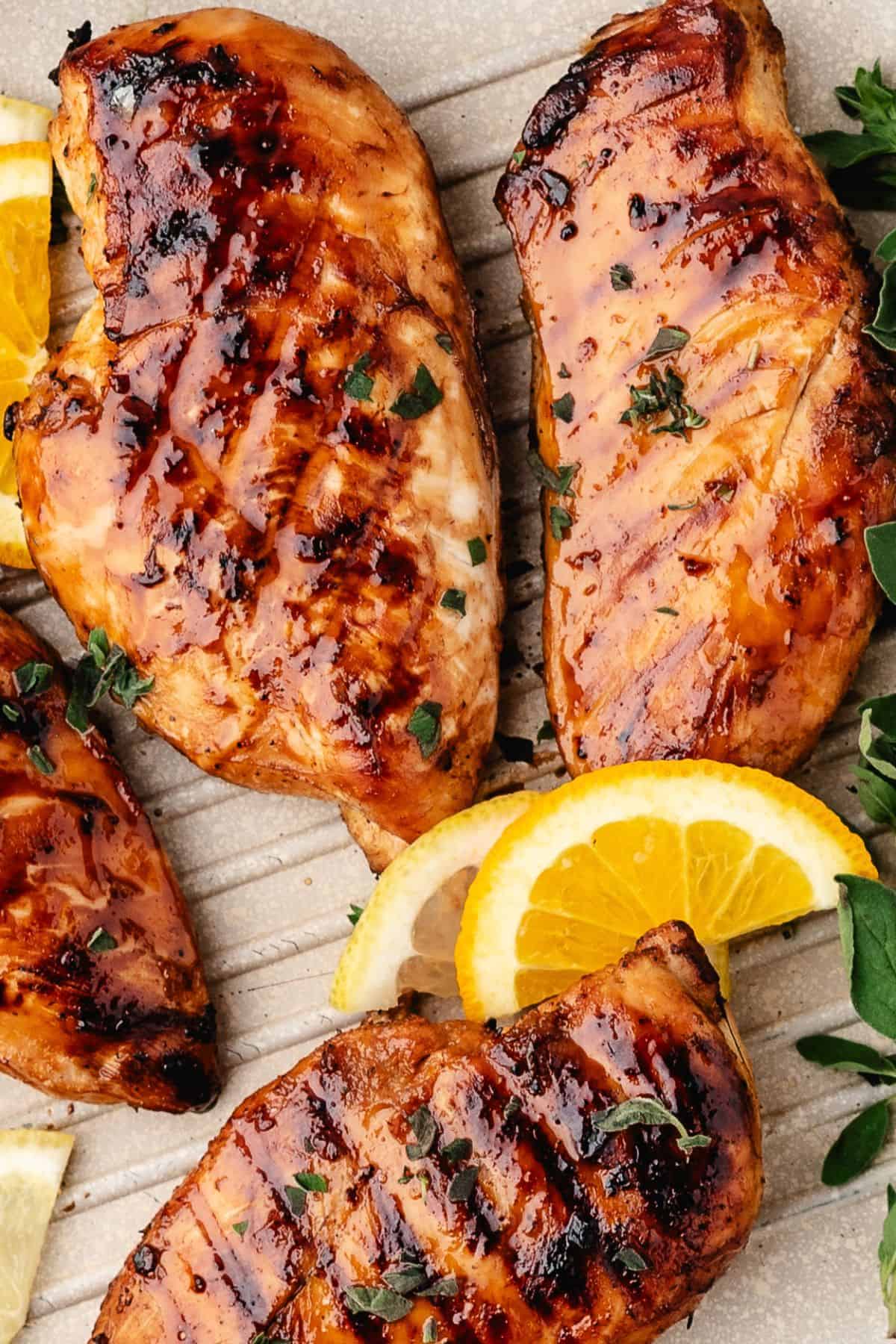 Plated marinated chicken breasts with citrusy lemon slices for garnish