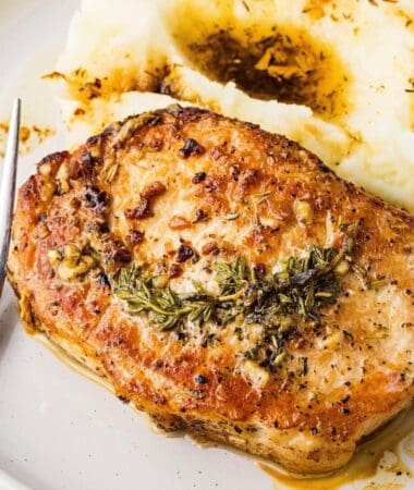 Golden seared pork chops with melted butter and herbs