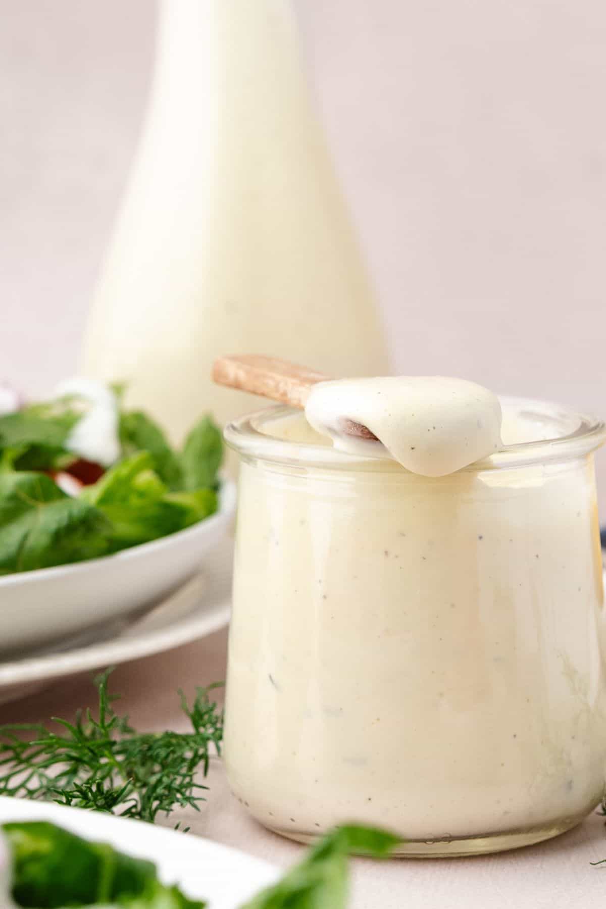 Creamy ranch dressing with specks of herbs in a container
