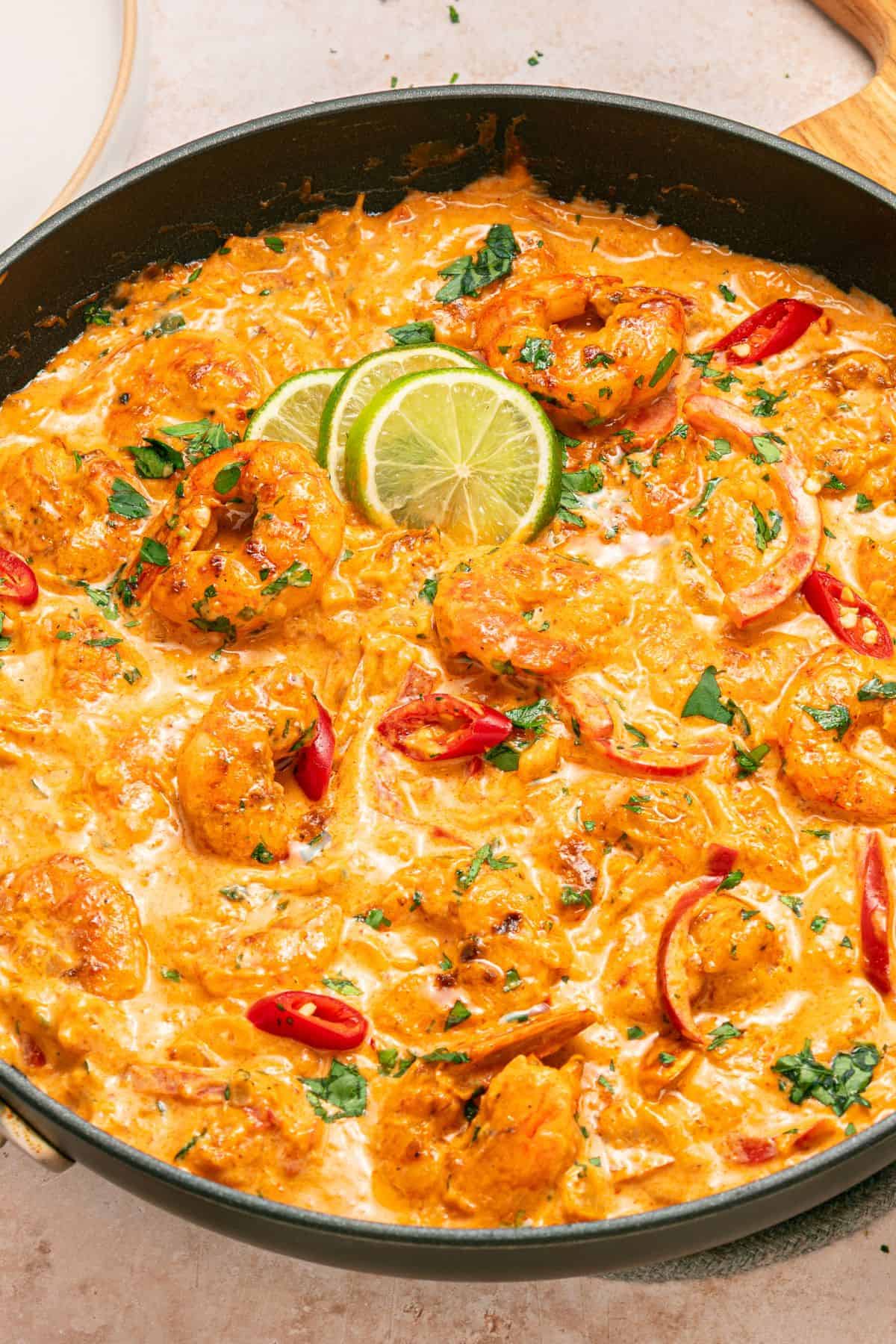Red curry shrimp in a skillet with creamy coconut sauce