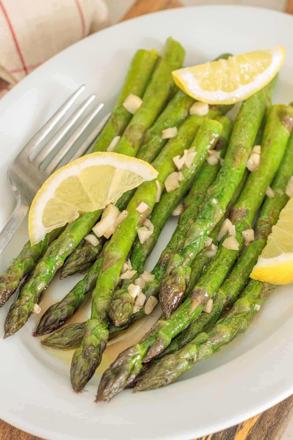 green asparagus saut&eacute;ed in butter and olive oil with lemon and garlic on a plate