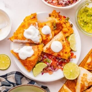 Cheesy shredded chicken quesadilla with saut&eacute;ed peppers on a serving plate