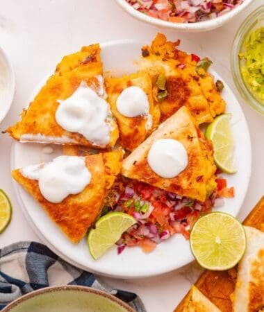 Cheesy shredded chicken quesadilla with sautéed peppers on a serving plate