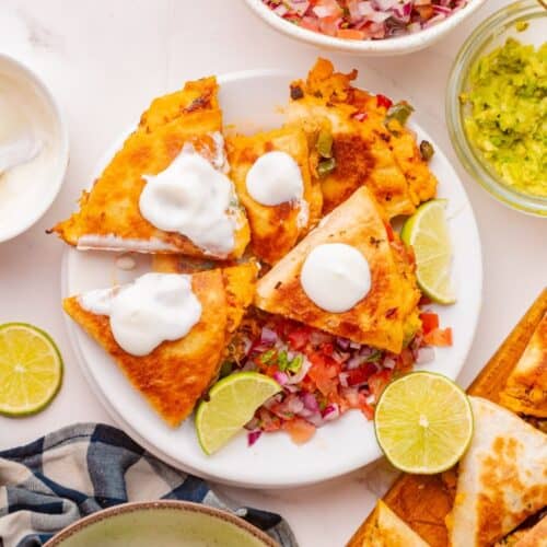 Cheesy shredded chicken quesadilla with sautéed peppers on a serving plate