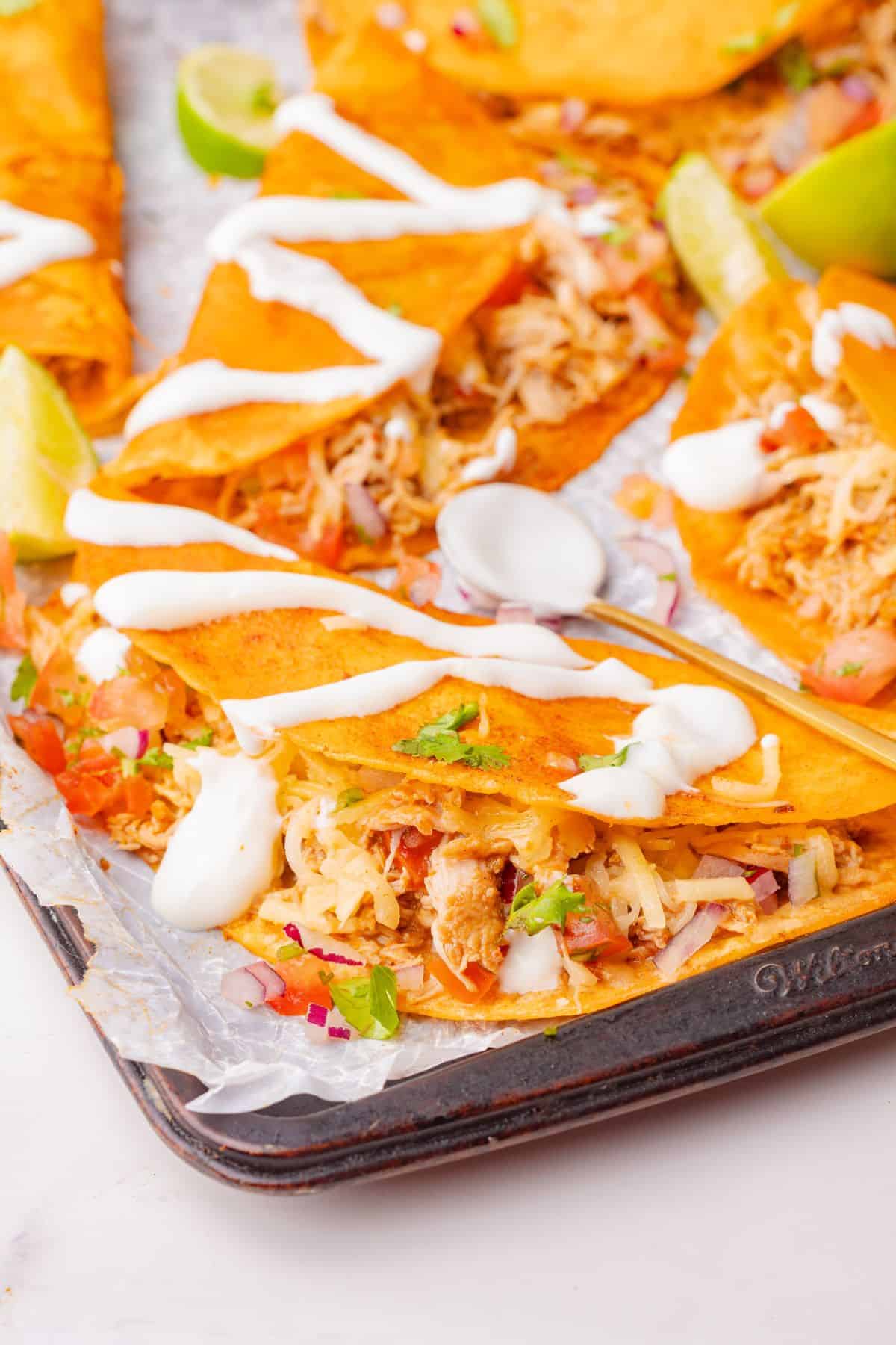 Crispy tortilla tacos stuffed with shredded chicken and cheese