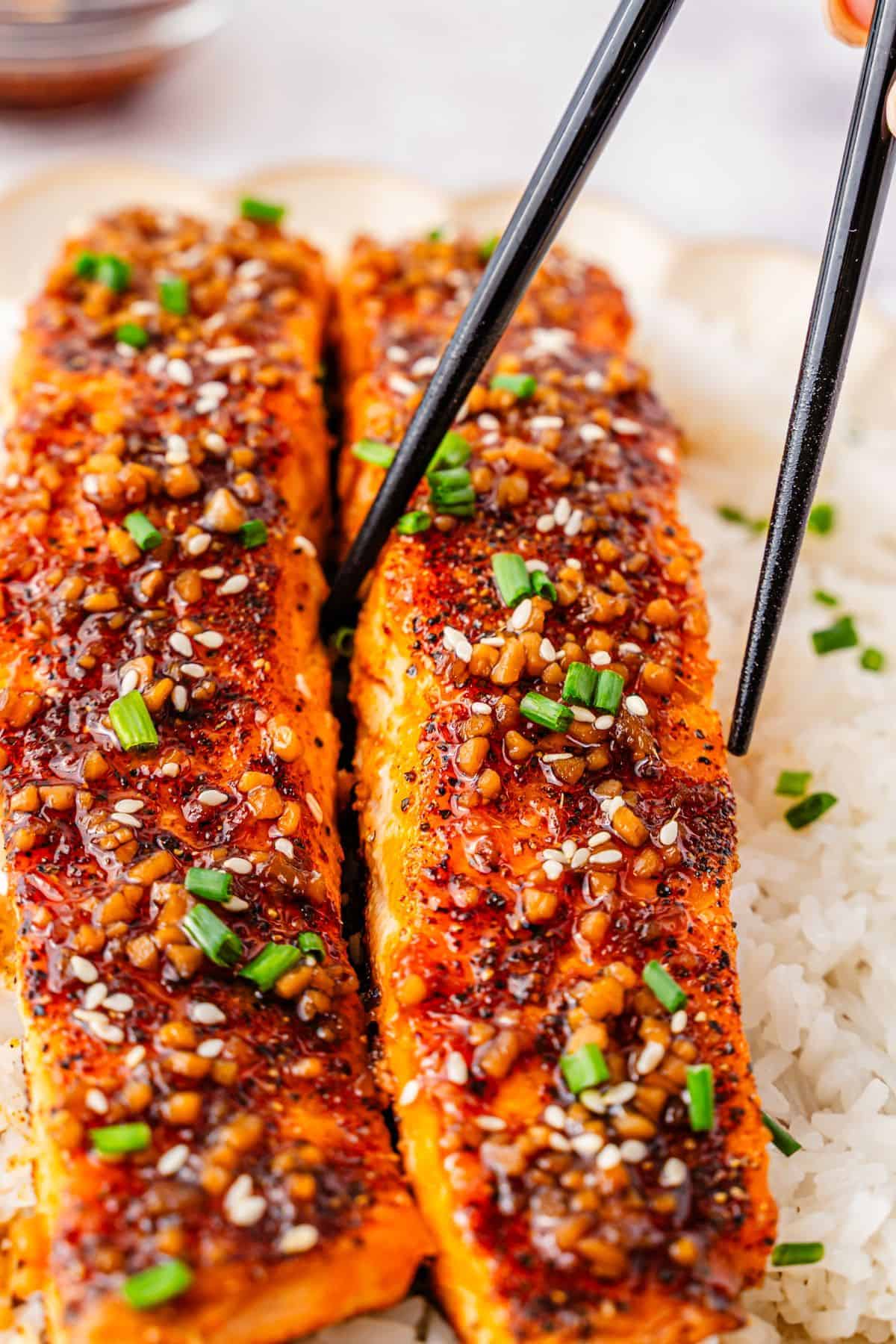 Teriyaki salmon served over rice with glossy savory sauce