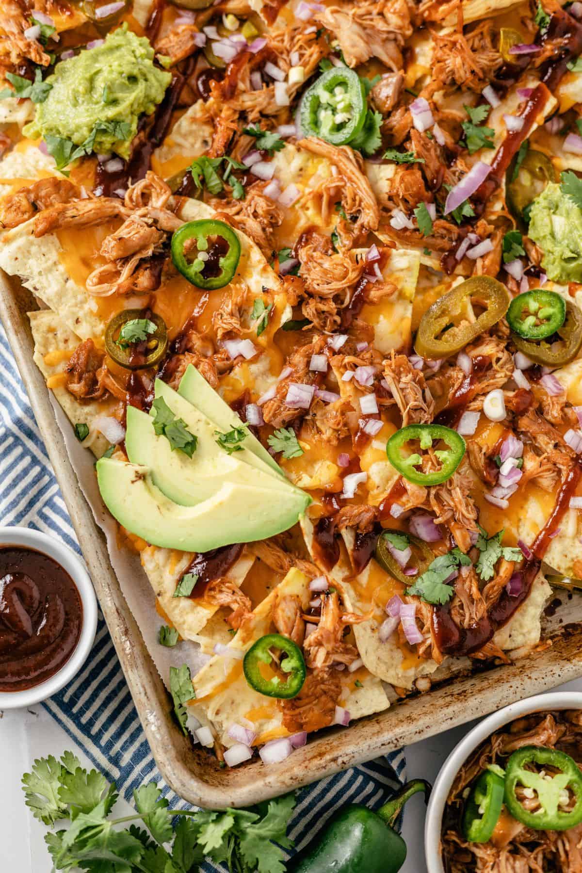 Pulled BBQ chicken nachos topped with cilantro and pickled jalape&ntilde;os